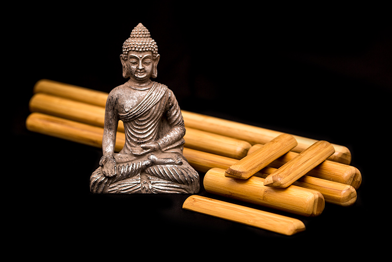Buddha Statue mit Bambusstäben